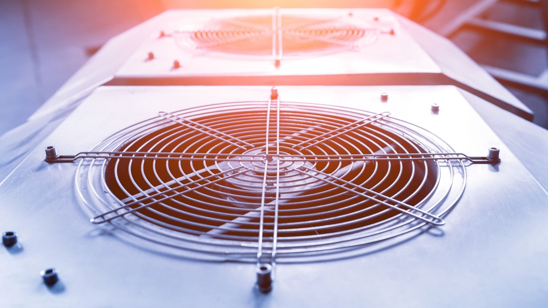 Industrial cooling fan with concentric wire coils mounted on white surface
