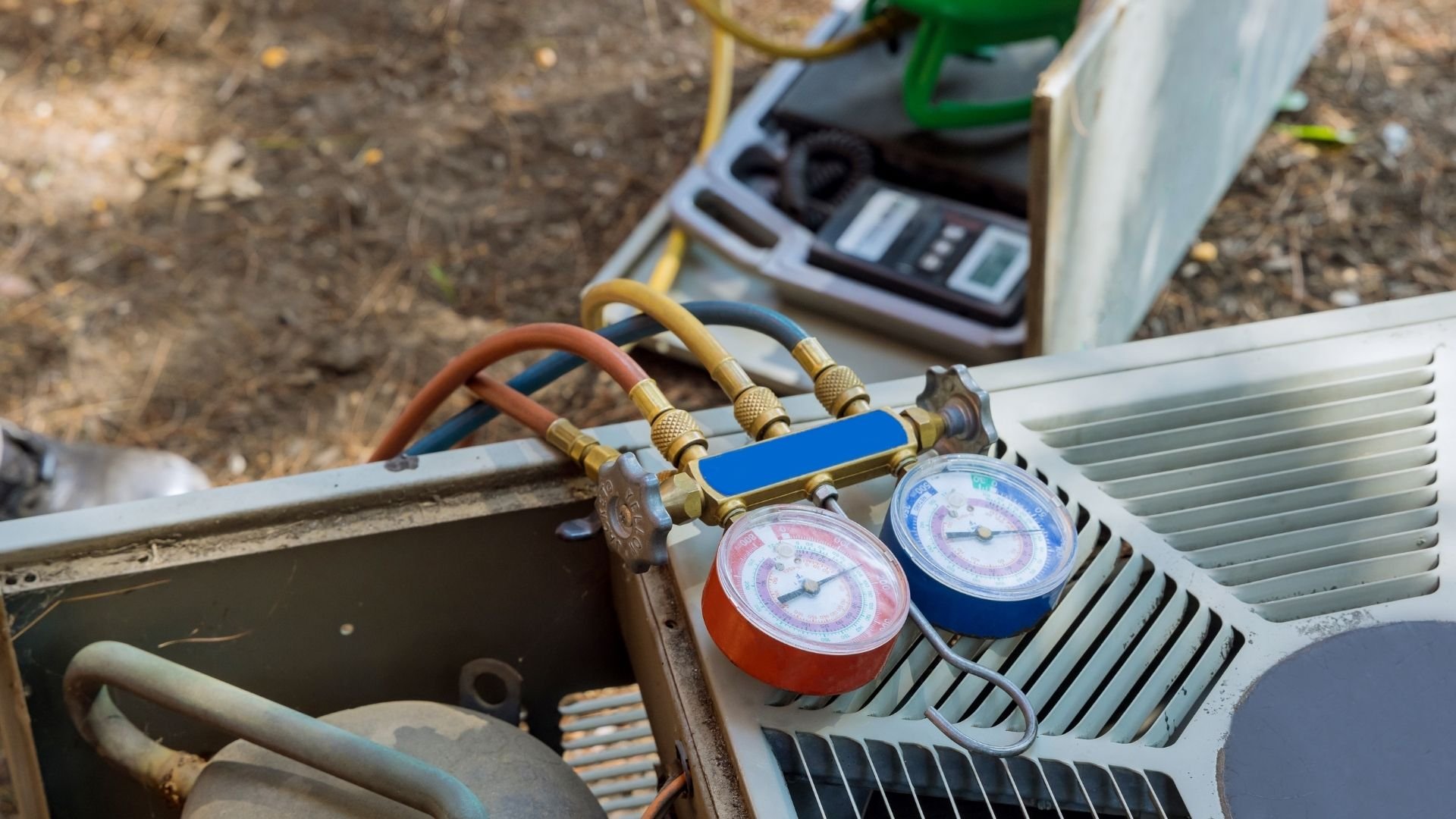 HVAC technician tools displaying pressure gauges and refrigerant lines for air conditioning system maintenance.
