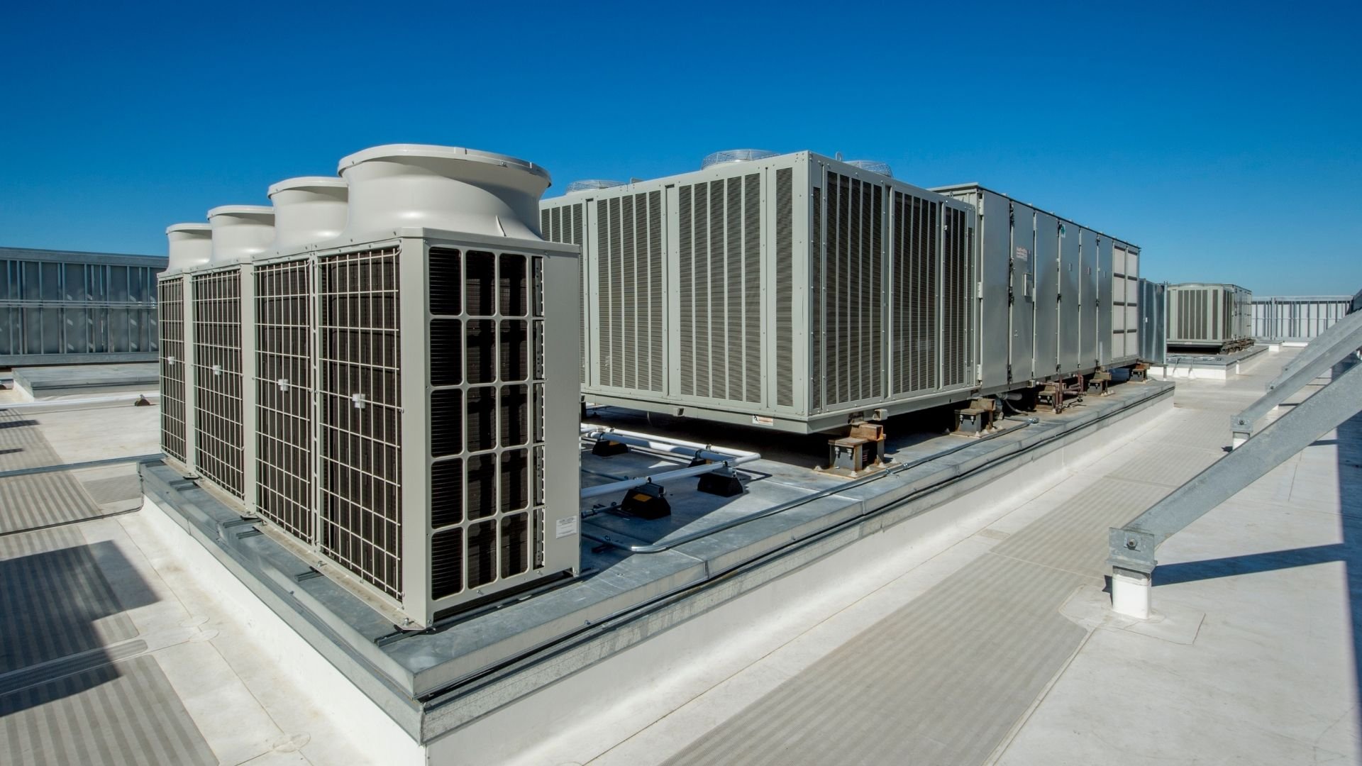 HVAC cooling towers and air conditioning units installed on commercial building rooftop